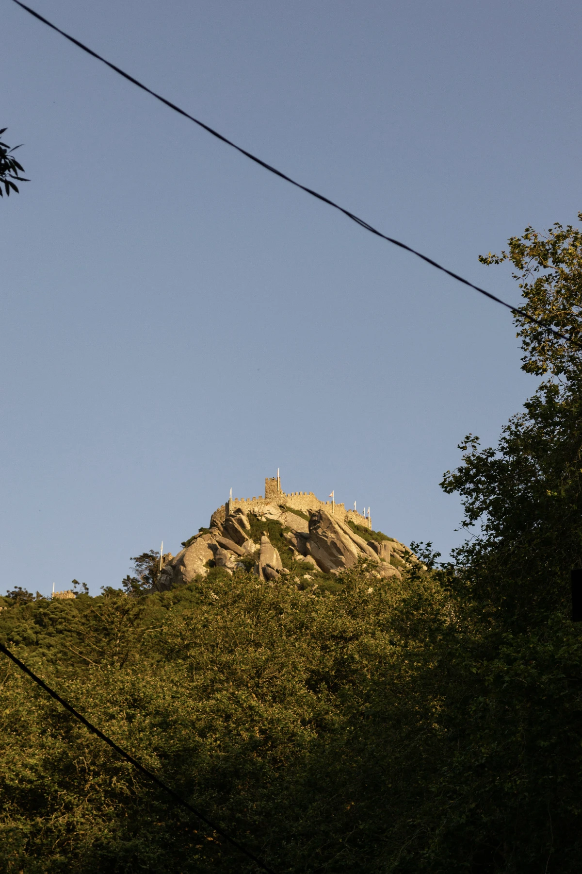 Photo of a castle up high on a hill somewhere close to Lisbon.