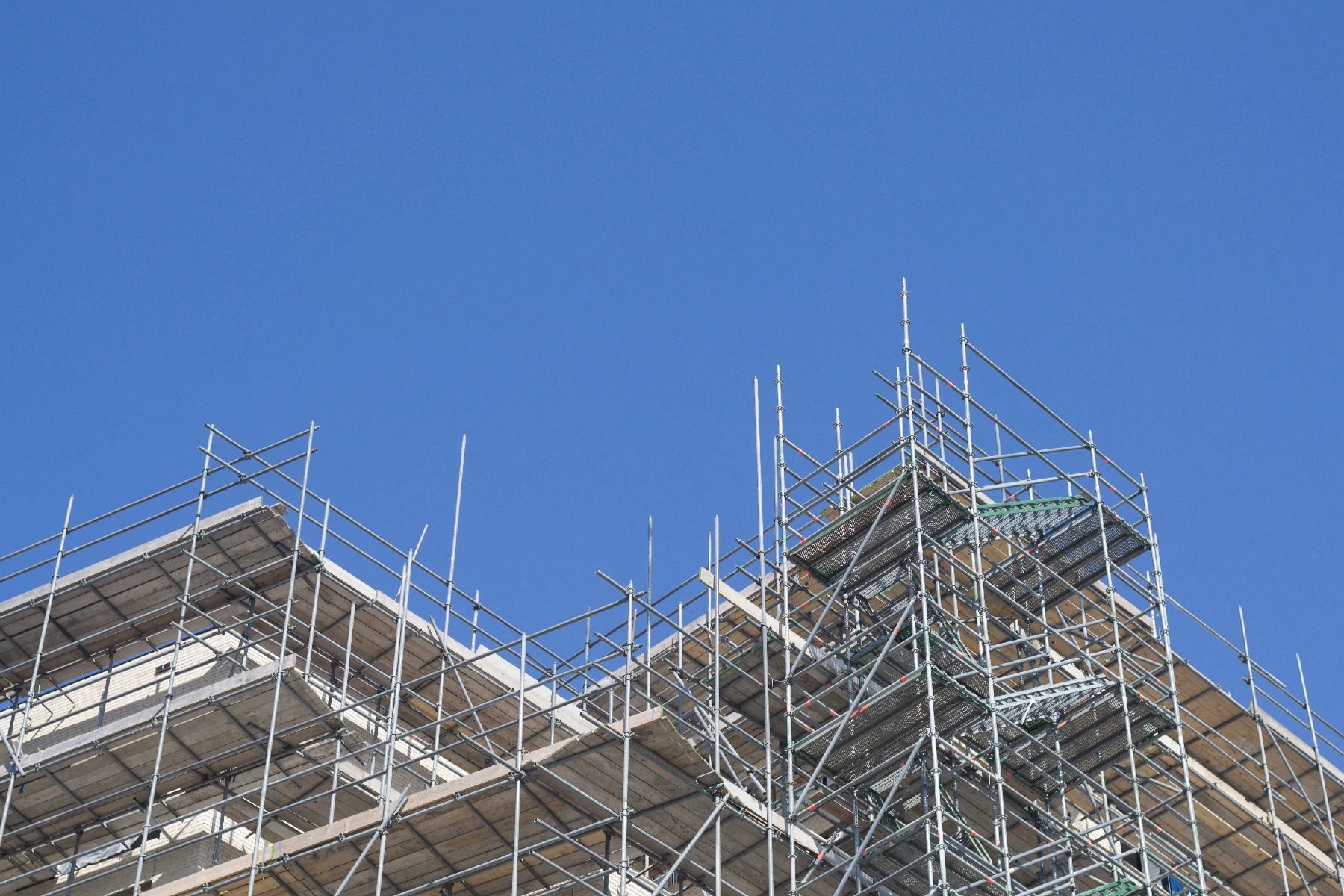 Photo of scaffolding with a clear blue sky.